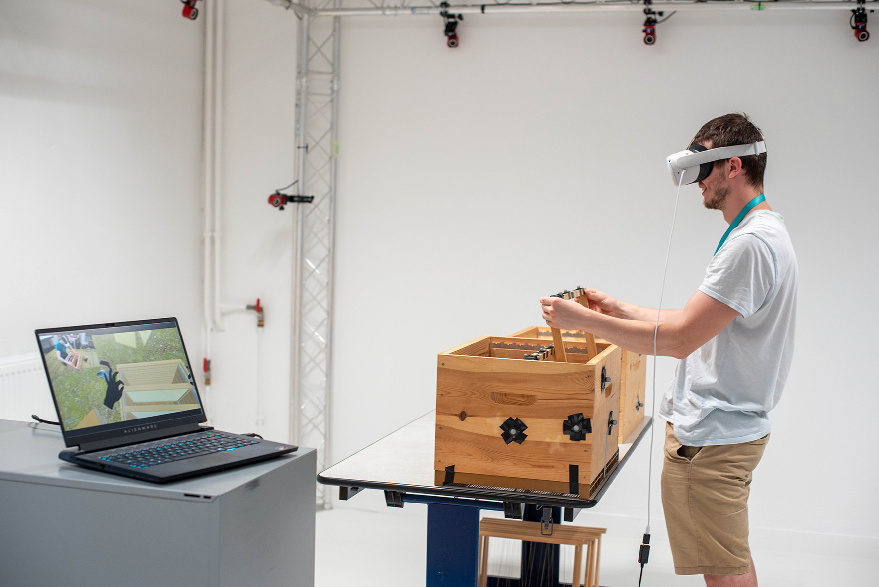 Un participant manipule un objet physique avec un casque de réalité virtuelle dans le laboratoire CEXI-HA